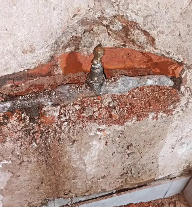Cañería reparada dentro de una pared abierta
